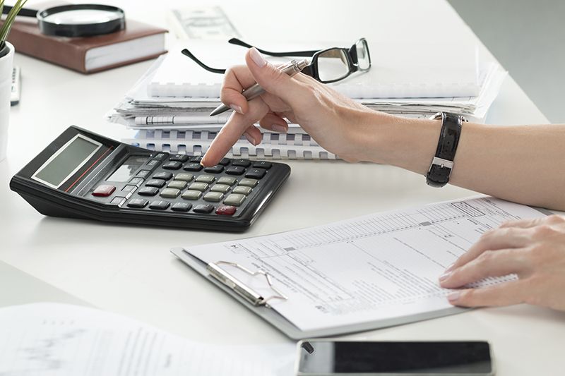 Close up of female accountant or banker making calculations. Savings finances and economy concept cm