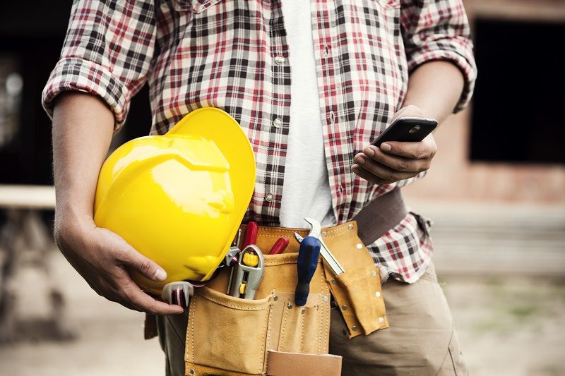Art 3 Construction worker typing on a smartphone L comp