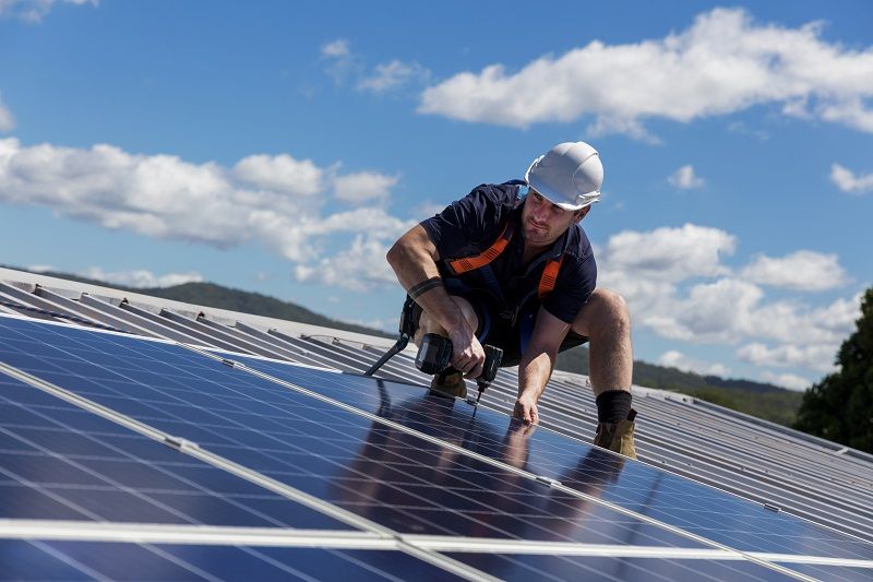 Solar-panel-installer-with-drill-installing-solar-panels-cm