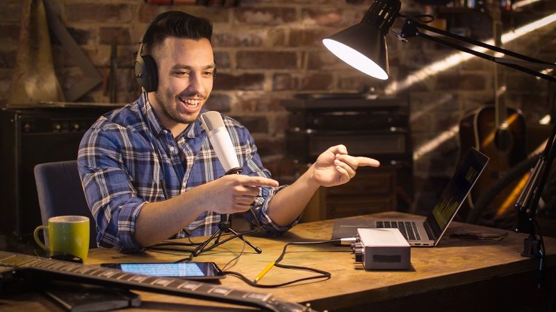 Young-man-makes-a-podcast-audio-recording-at-home-in-a-garage-cm