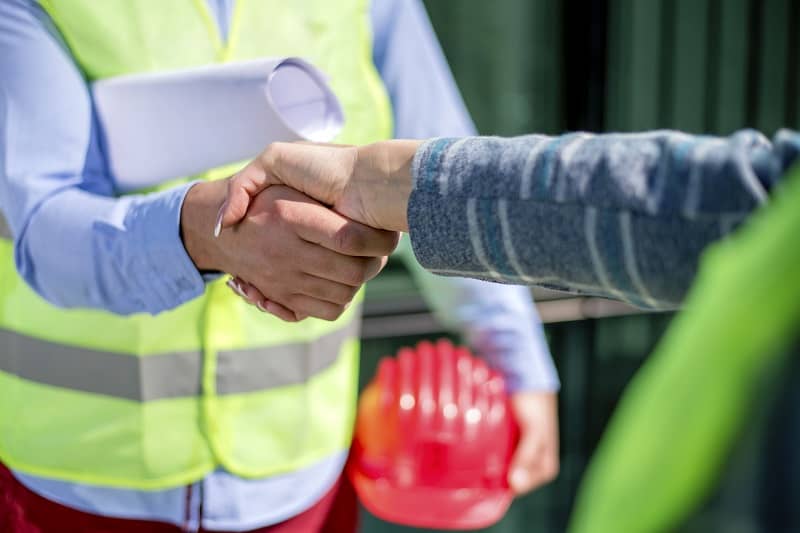 Construction worker shaking hands with manager-cm