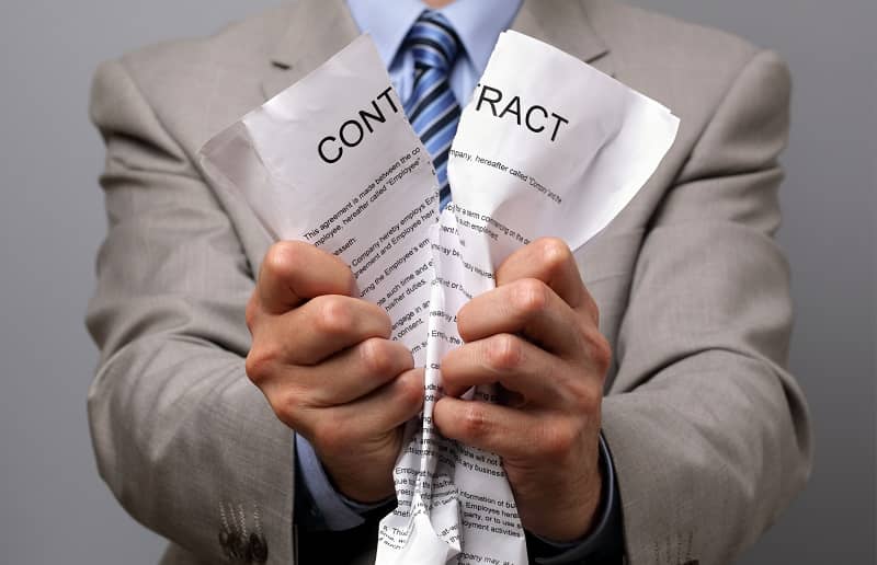 Man in business wear tearing up a contract with his hands-cm