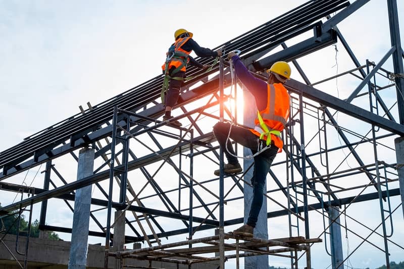 Construction worker wearing safety harness.-cm