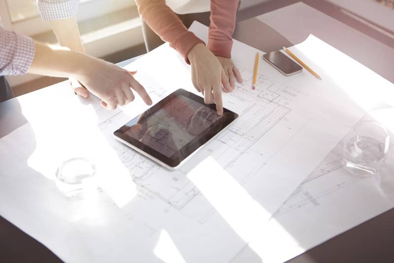 Business people discussing plans on tablet-cm