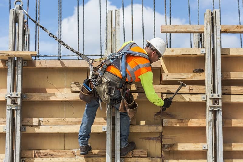 Caucasian worker hammering wood at construction site-cm (1)