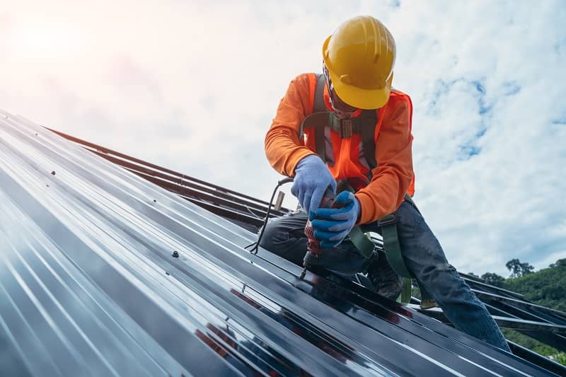 Roofer worker in special protective work wear and gloves.-cm