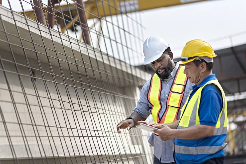 An engineer and worker are checking cement board at cement factory.-cm