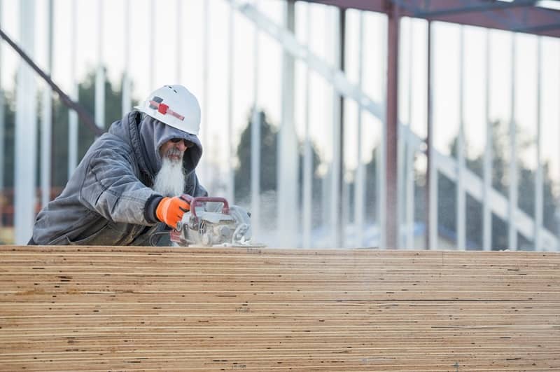 USA, Montana, Kalispell, Man cutting wooden planks -cm
