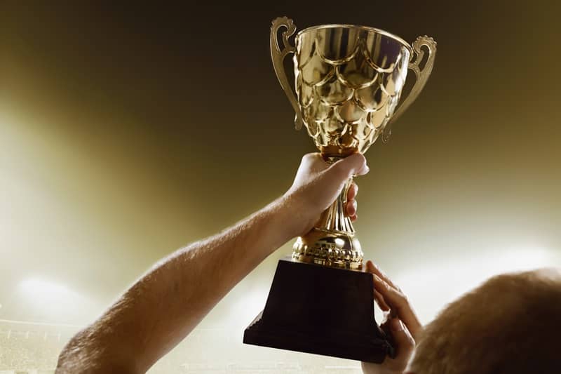 Athlete holding trophy cup above head in stadium-cm