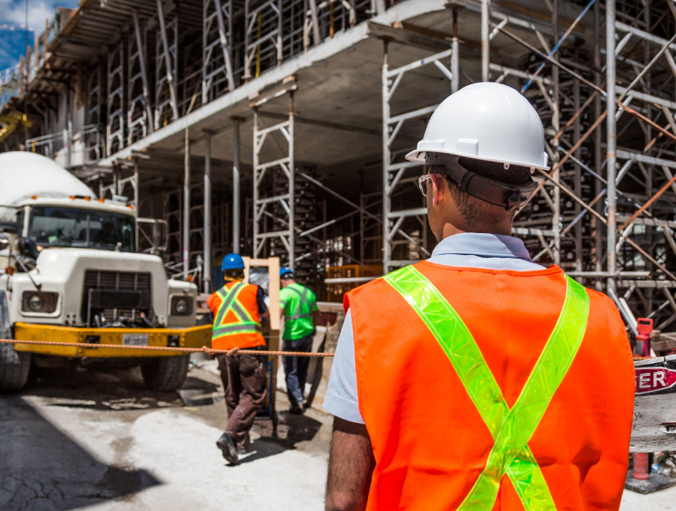 Construction workers on a large-scale jobsite with safety gear, representing customized staffing solutions for large-scale construction projects.